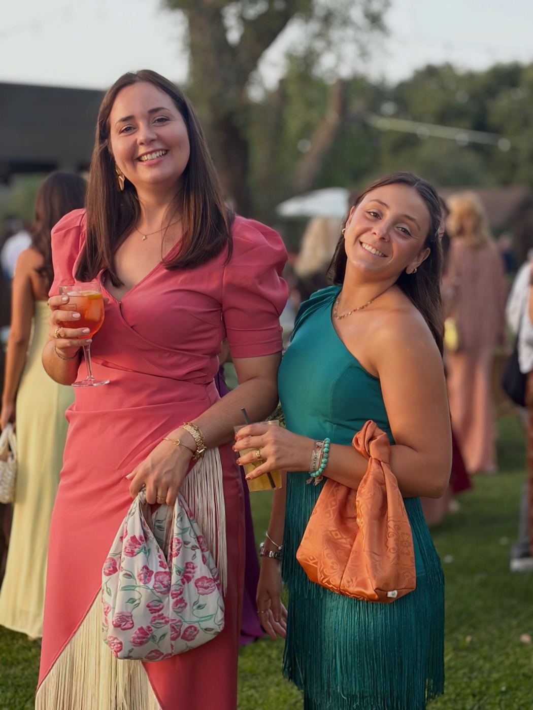 Duas convidadas com malas de nó floral e terracota