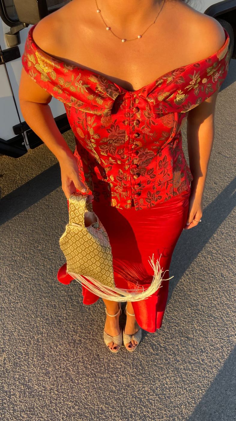 Look vermelho com mala dourada com franjas