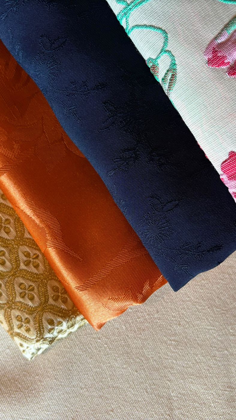 Tecidos jacquard dourado, terracota, azul-marinho e floral